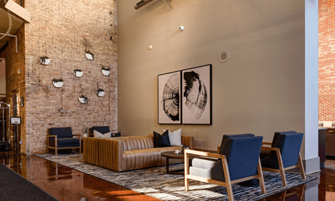 A living room with a couch, chairs, and a painting on the wall.