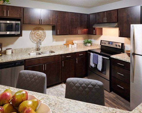 A kitchen with brown cabinets and a white refrigerator.