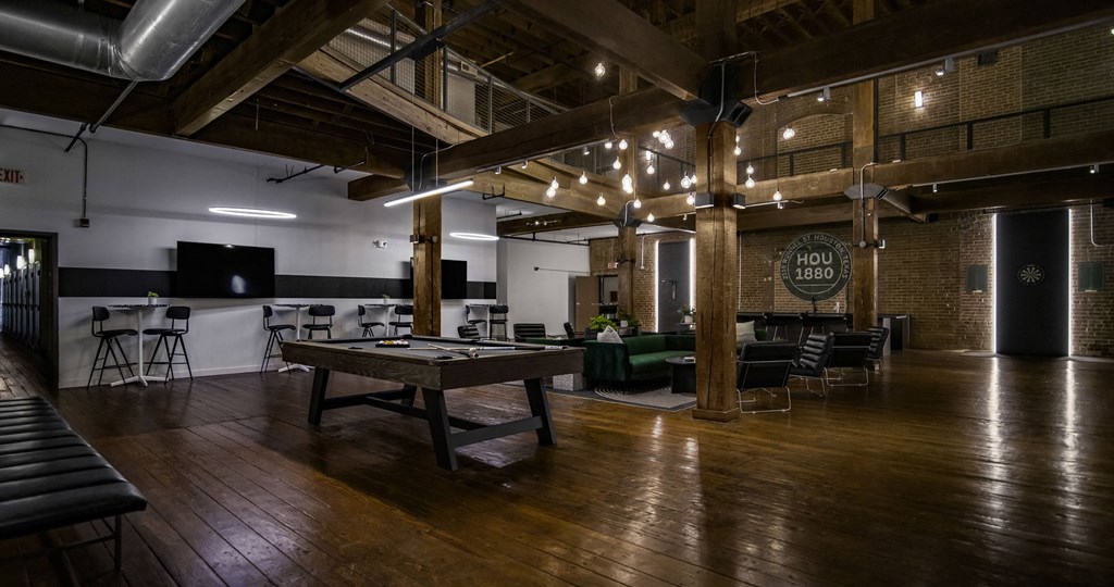 A room with wooden floors and a long table with chairs around it.