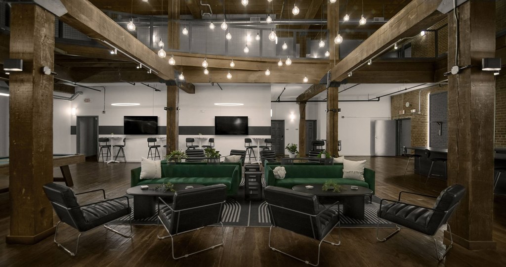 A modern office space with a green couch and black chairs.