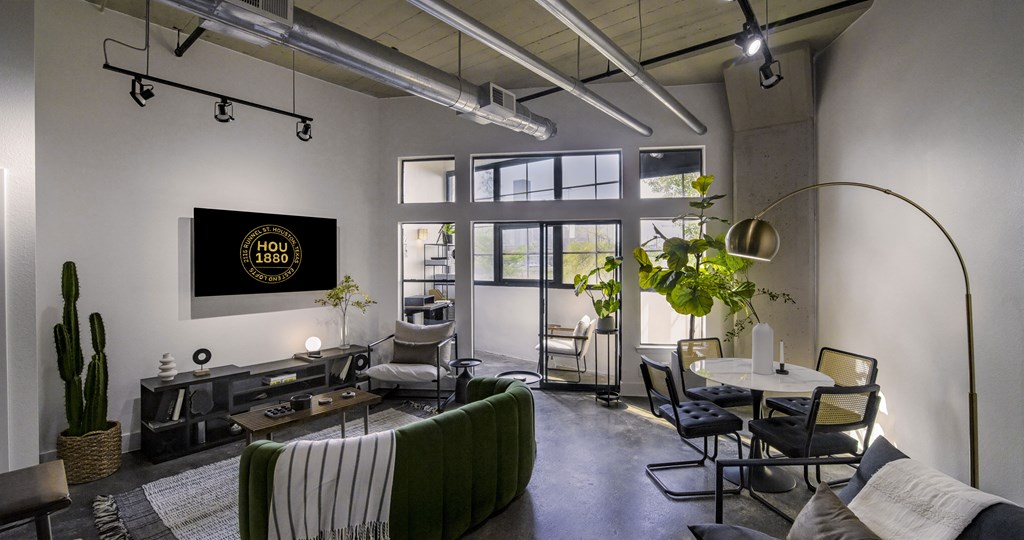 A living room with a couch, chairs, and a television displaying the text "HOLLYWOOD 1939".