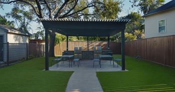 A patio with a table and chairs under a roof.