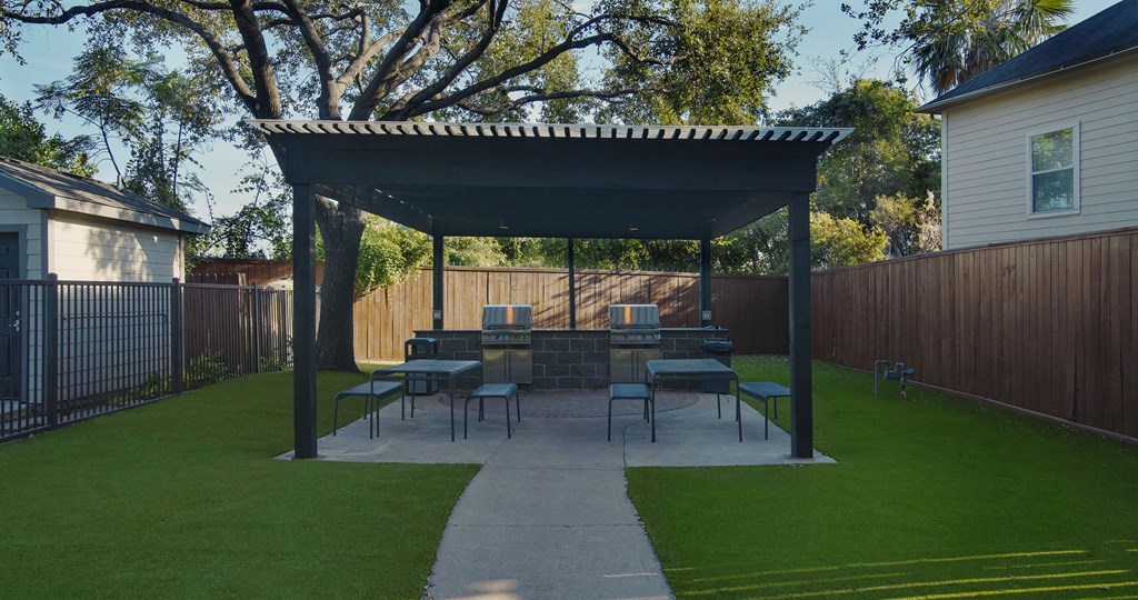 A patio with a table and chairs under a roof.