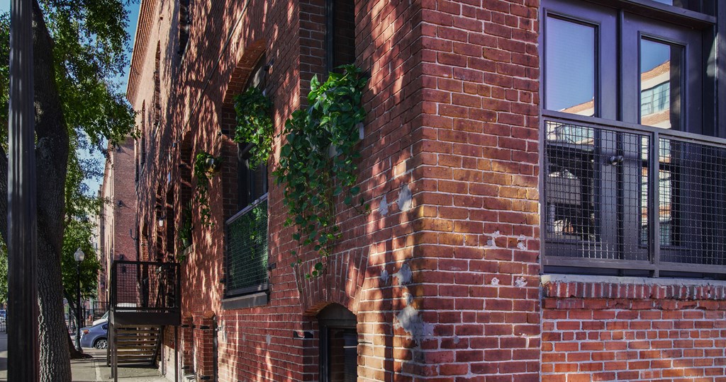 A red brick building with a balcony and a door.