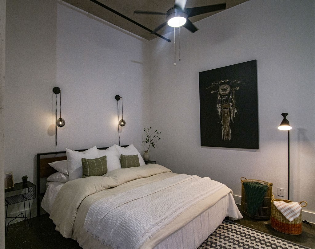 A bedroom with a large bed and a ceiling fan.