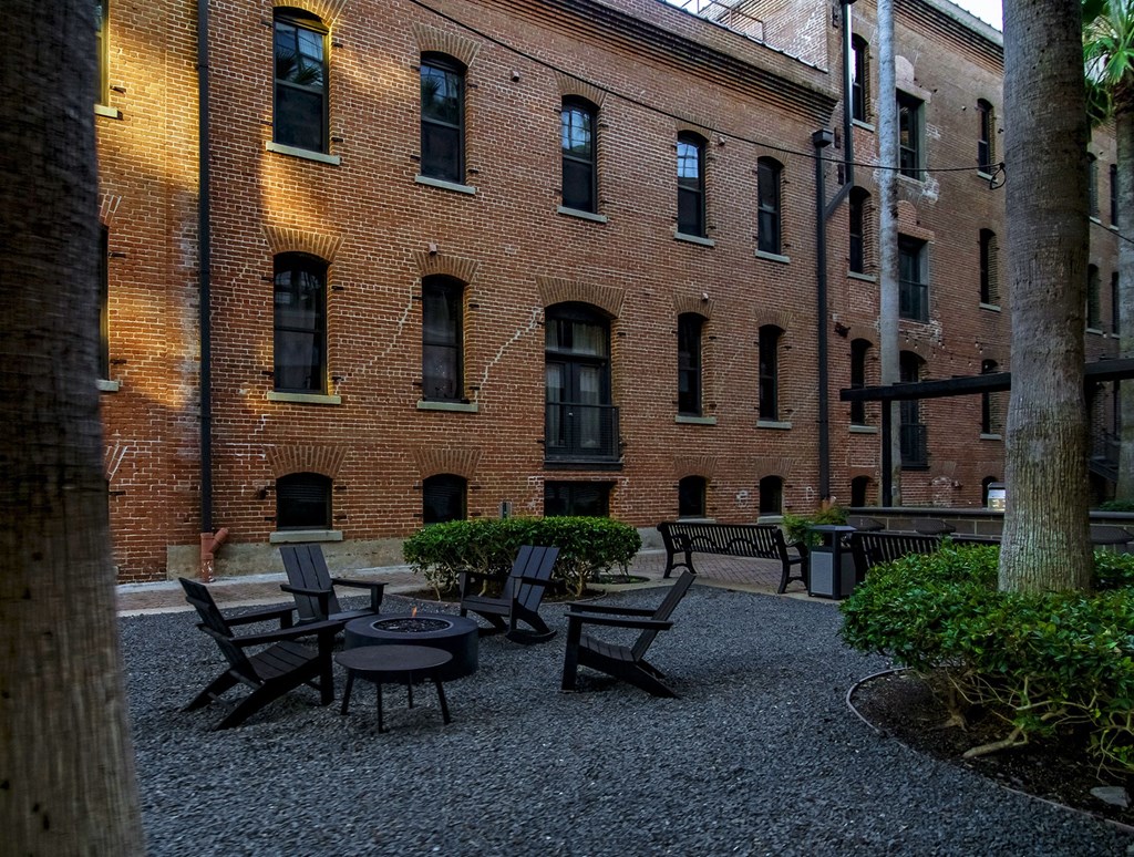 A courtyard with a table and chairs surrounded by brick buildings.