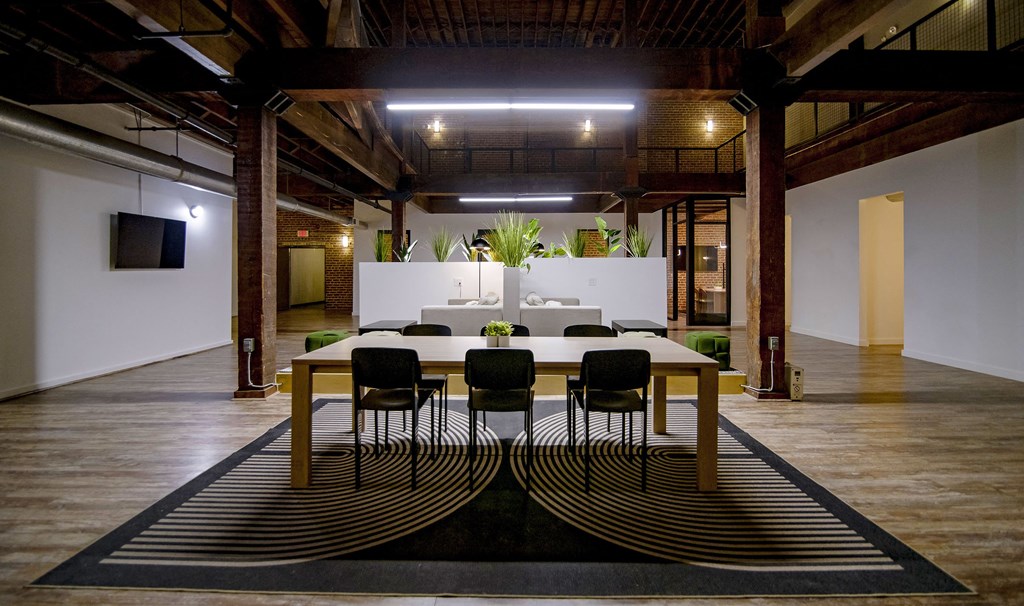 A conference room with a long table and chairs in the center.