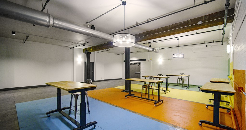 A room with tables and chairs and a blue floor.