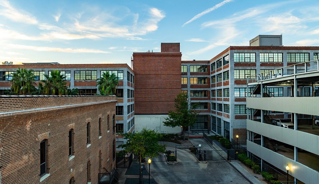 A view of a courtyard between two buildings with a brick chimney in the middle.