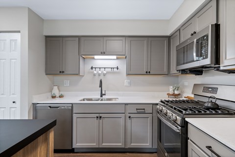 A kitchen with a white stove top oven and a white dishwasher.