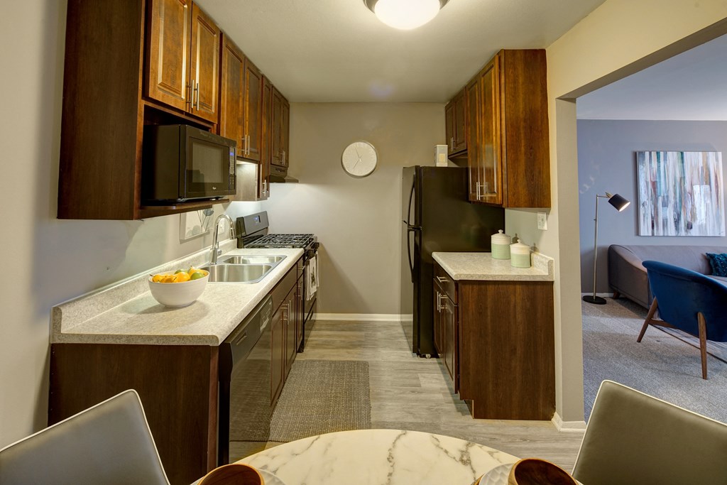 a kitchen with wooden cabinets and a sink and a refrigerator