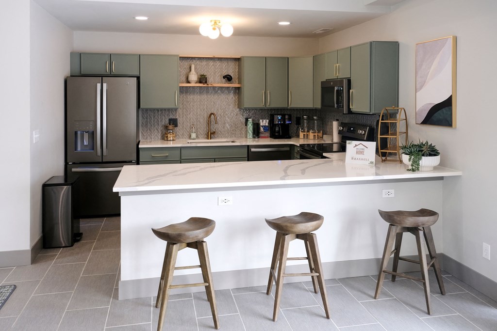 renovated kitchen featuring sage cabinets and bar seating
