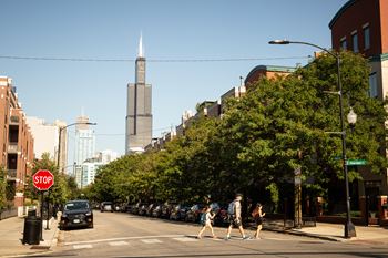 A street scene with a stop sign and people crossing the road.
