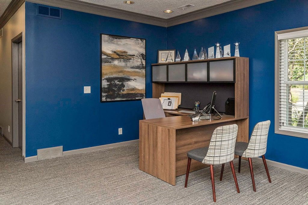 Fairlane Woods leasing office with blue walls and a wood desk