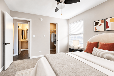 A bedroom with a large bed and a ceiling fan.