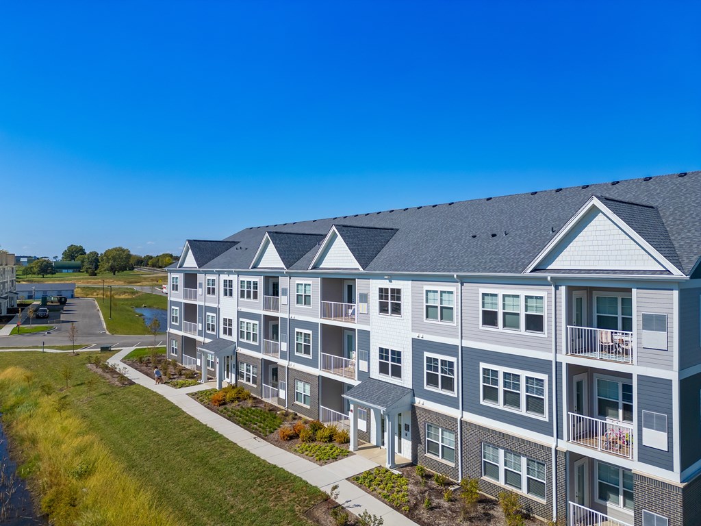 A modern apartment building with balconies and a clear blue sky.