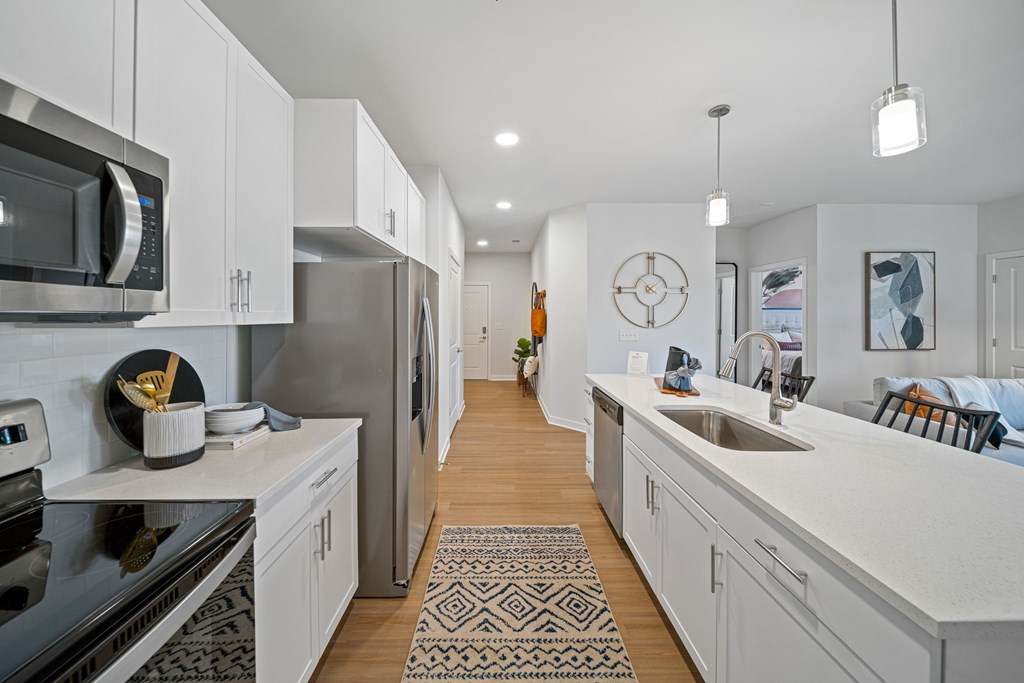 A modern kitchen with white cabinets and a black stove top.