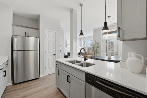 A modern kitchen with a stainless steel refrigerator and a white countertop.