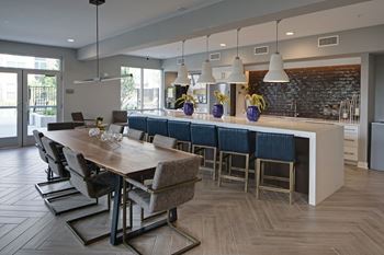 A modern dining room with a long wooden table and grey chairs.