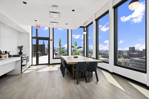 A modern kitchen with a dining table and chairs with a view of the city.