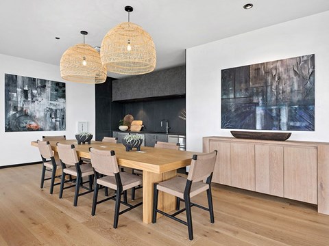 A modern dining room with a wooden table and chairs.