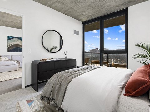 A bedroom with a large bed and a view of the city.