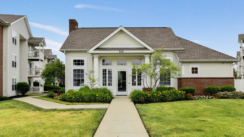 a white house with a sidewalk in front of it
