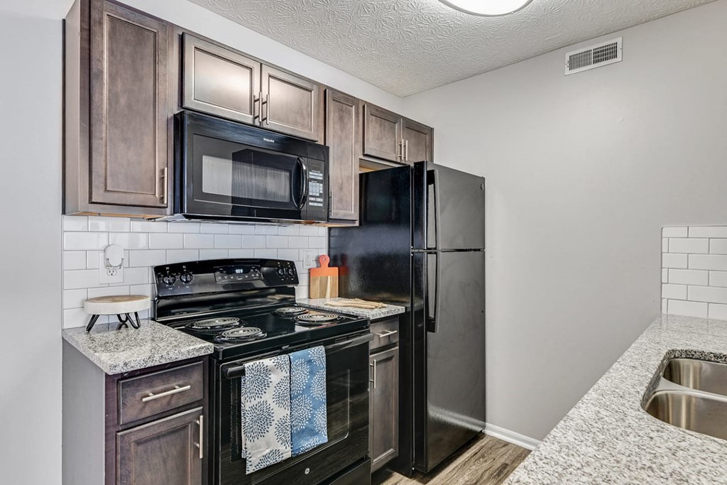 our apartments have a modern kitchen with black appliances and granite counter tops