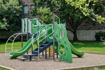 a playground with a green slide and stairs
