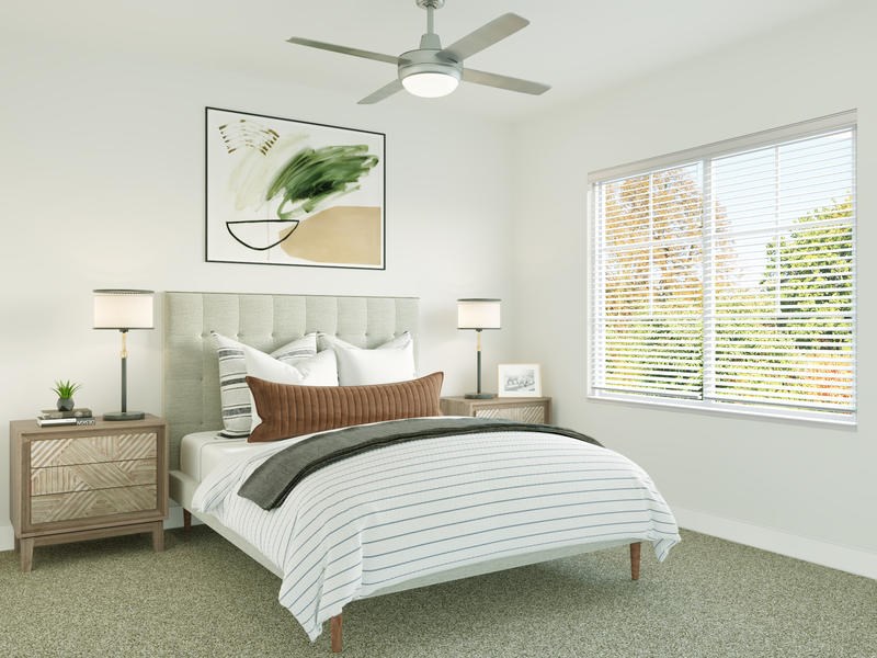 A bedroom with a bed, nightstand, and a ceiling fan.