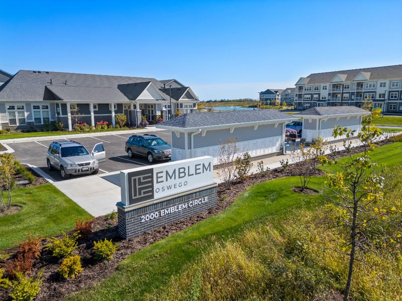 A sign that says Emblem Oswego 2000 Emblem Circle is in front of a building.