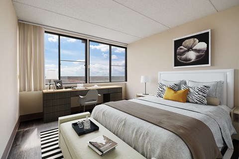 A bedroom with a large bed and a desk with a chair.