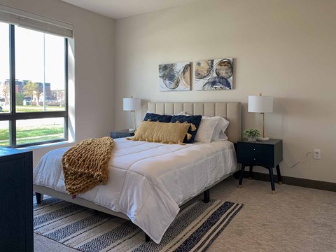 a bedroom with a bed and a large window