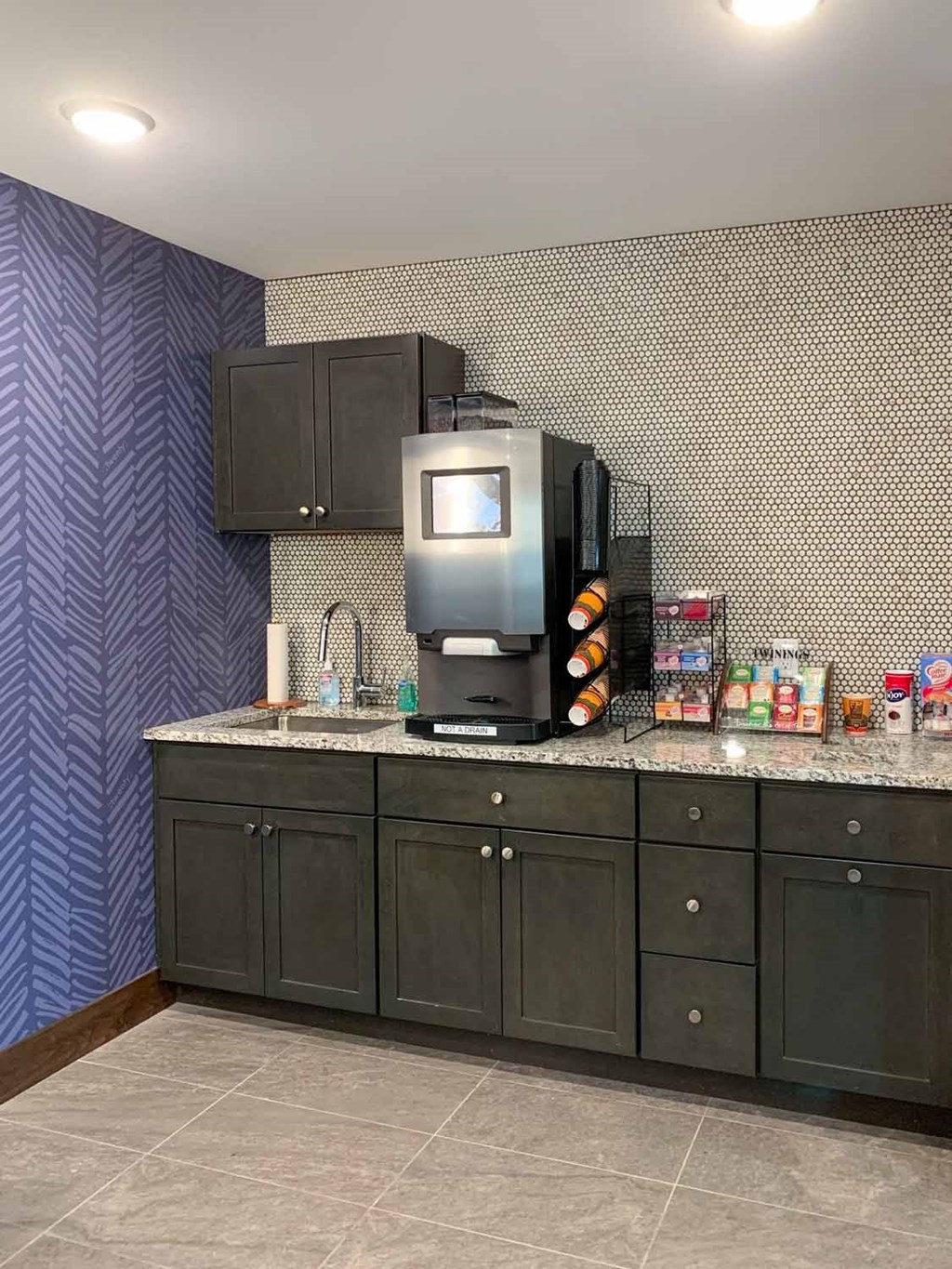 A coffee bar featuring an espresso and latte maker, tea station, and creamers and sugar