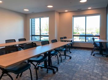 A conference room with several long wooden tables and chairs