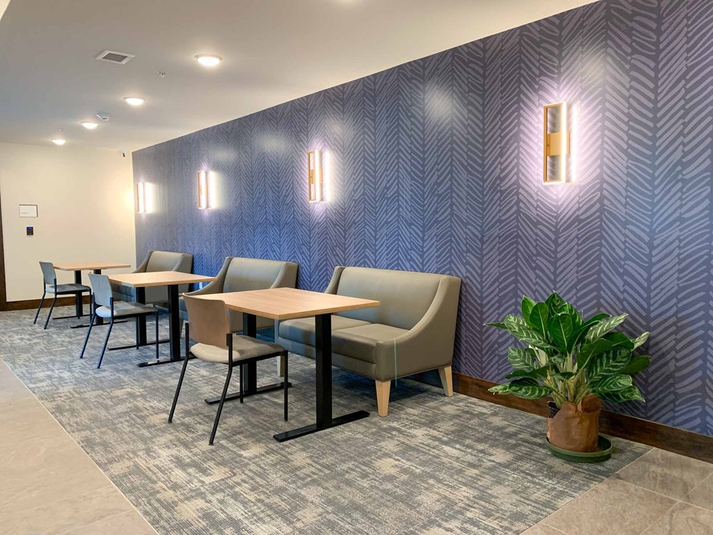 The coffee lounge with booths and tables with a patterned wall