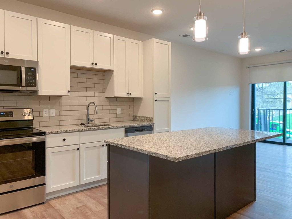 a kitchen with white cabinets and large island