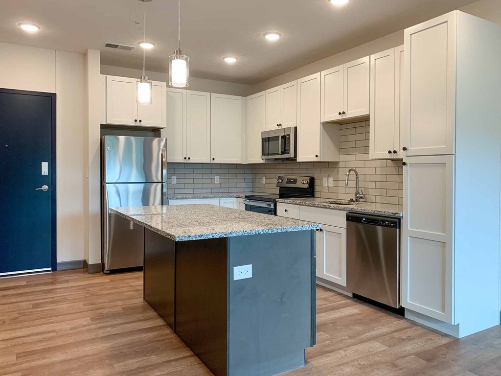 a kitchen with stainless steel appliances and white cabinets