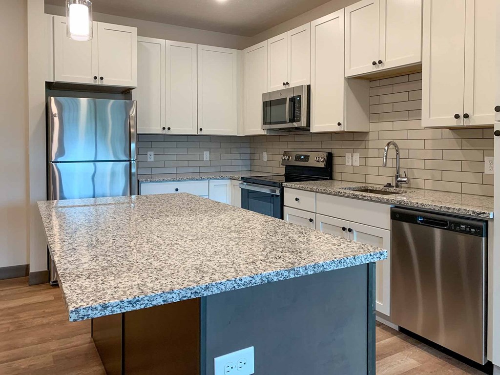 a kitchen with a counter top and a stainless steel refrigerator