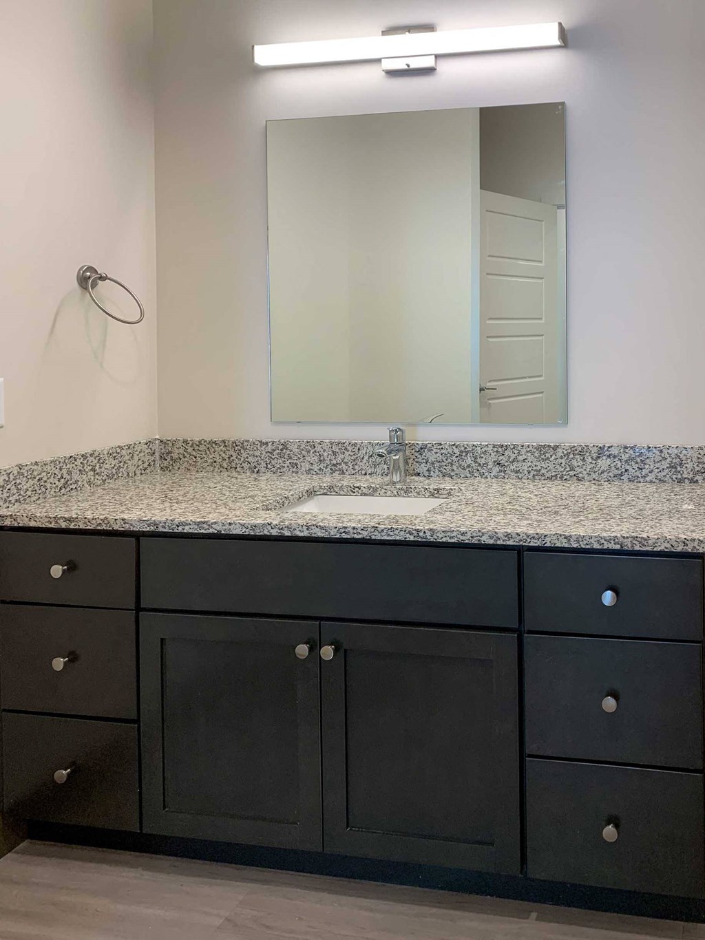 a bathroom with a granite vanity and large mirror