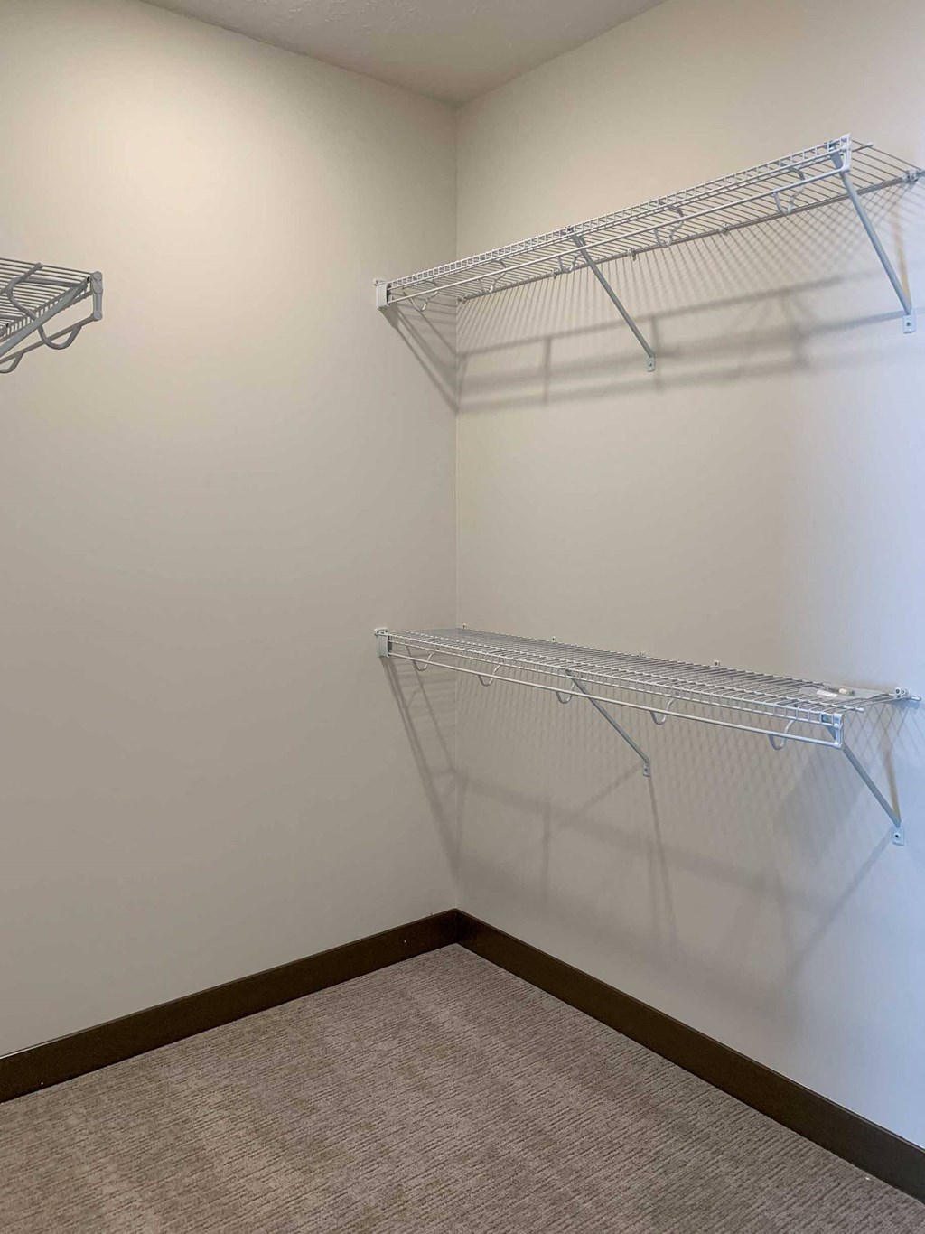 a walk in closet with shelves on the wall