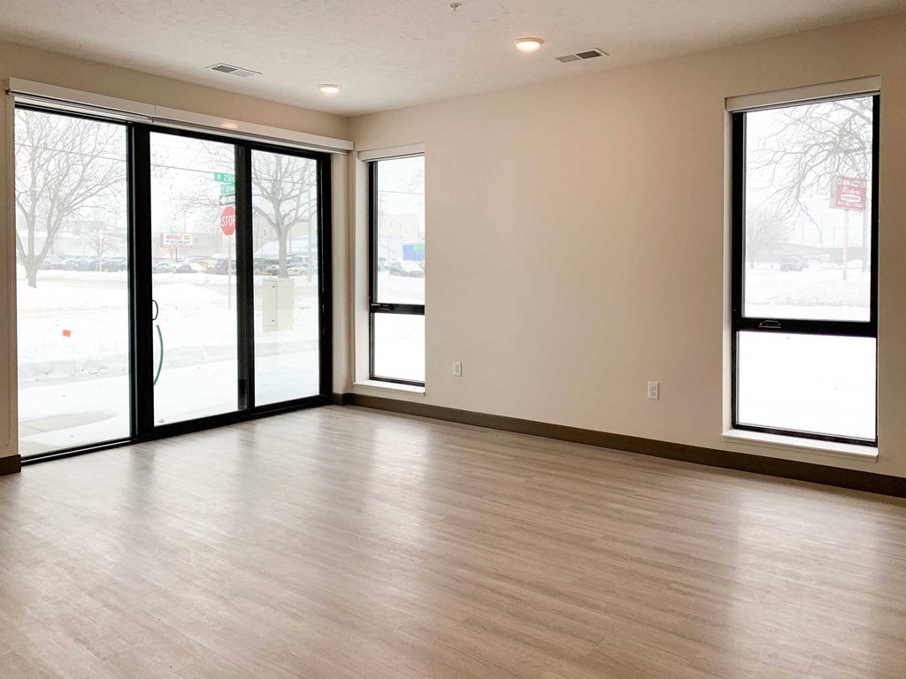 a living room with a wood floor and large windows