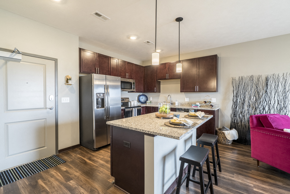 One bedroom apartment kitchen with dark cabinetry and stainless steel appliances at 360 at Jordan West best new apartments West Des Moines IA 50266