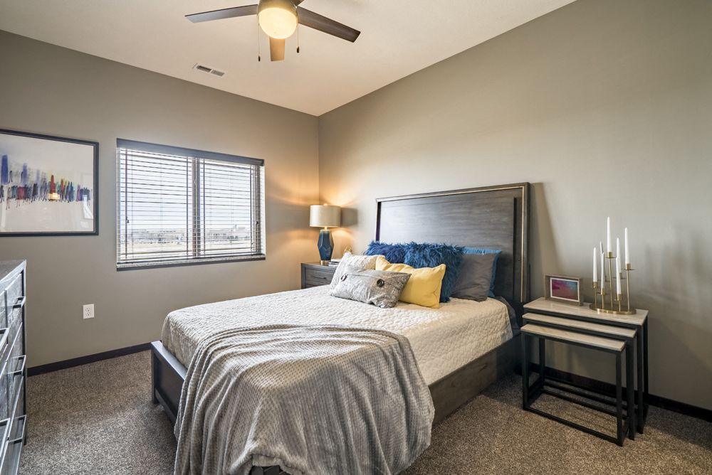 Bedroom with ceiling fan and natural lighting at 360 at Jordan West best new apartments West Des Moines IA 50266