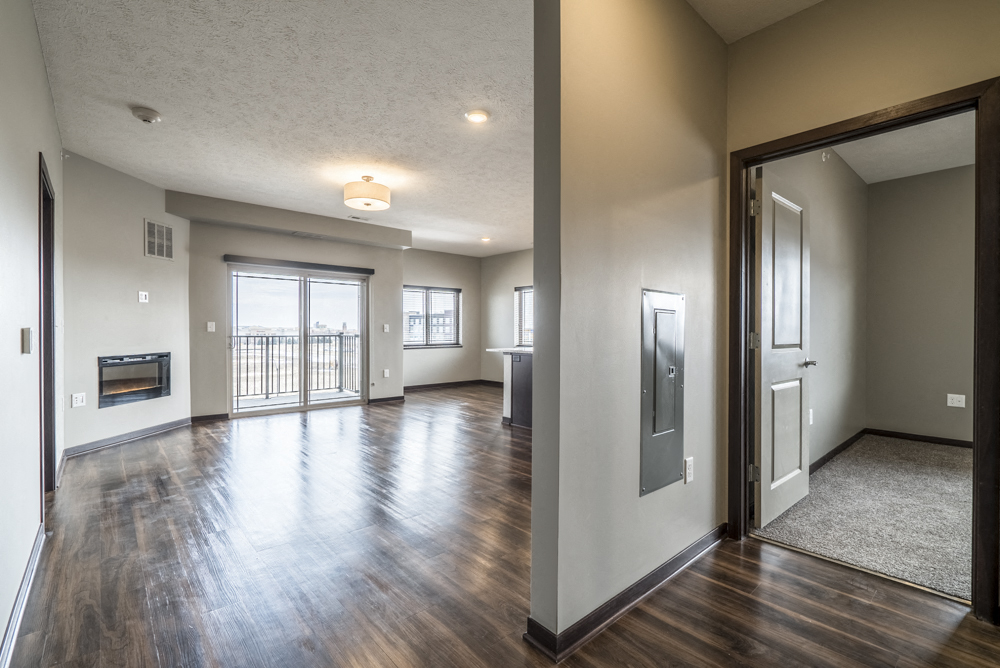 View of living room in two bedroom apartment with hardwood-style floors at 360 at Jordan West best new apartments West Des Moines IA 50266