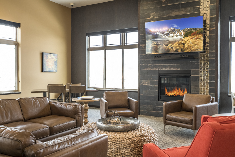 Clubhouse TV lounge area with leather couches at 360 at 360 at Jordan West best new apartments West Des Moines IA 50266