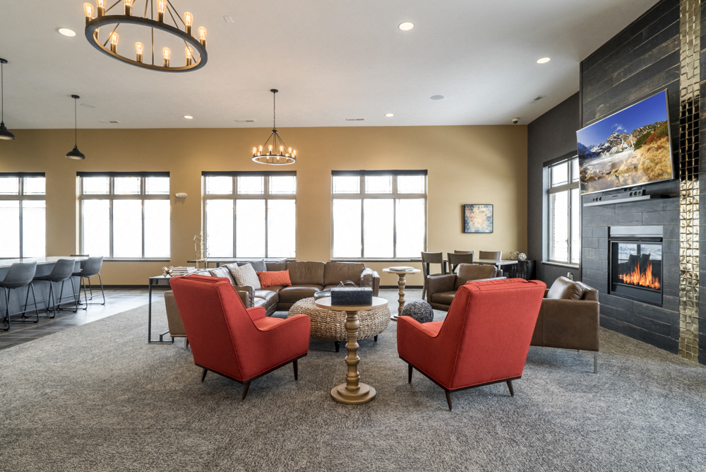 Clubhouse interior with seating, TV and fireplace at 360 at Jordan West best new apartments West Des Moines IA 50266