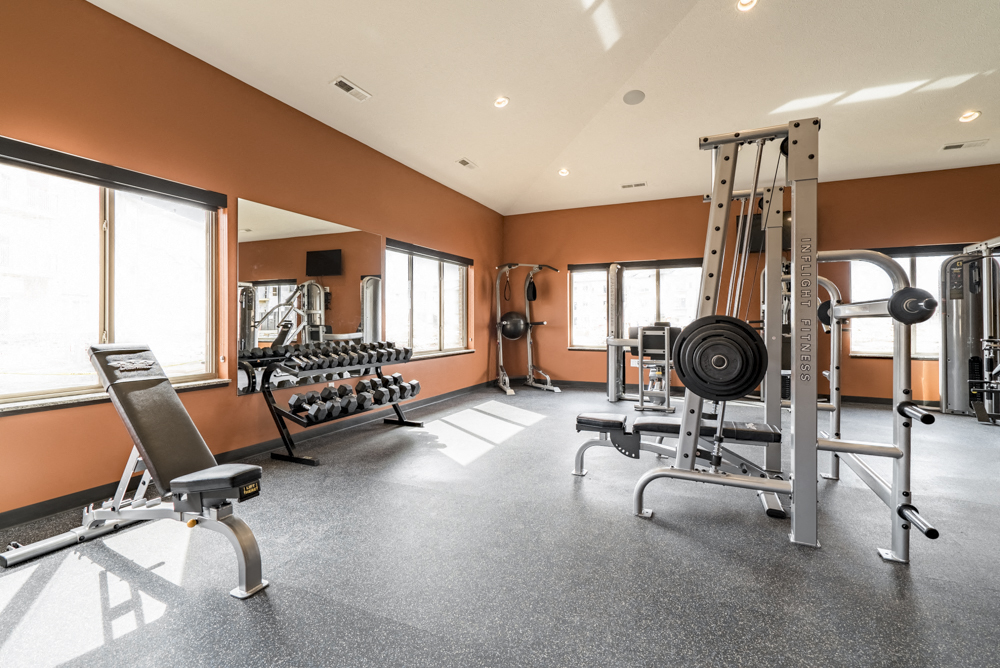 Fitness center with free weights, weightlifting machines and cardio equipment at at 360 at Jordan West best new apartments West Des Moines IA 50266