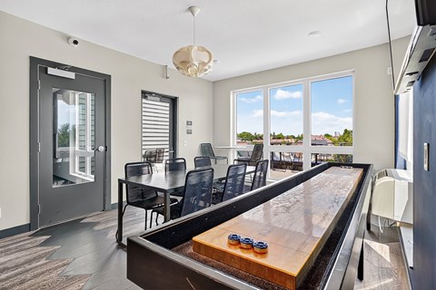A shiny pool table is in the middle of a room with a glass door.