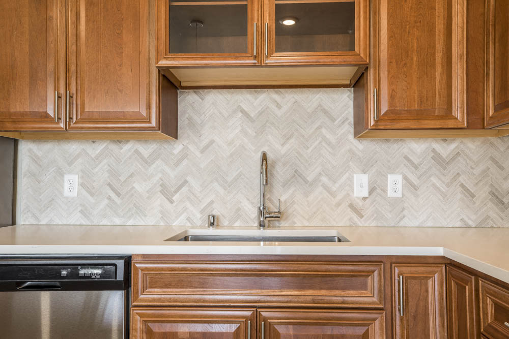 Ascend at Woodbury luxury apartment with herringbone backsplash in kitchen